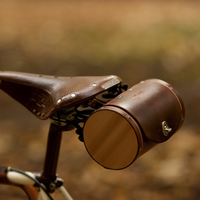 Dark brown leather barrel bicycle bag mounted on Brooks bike seat
