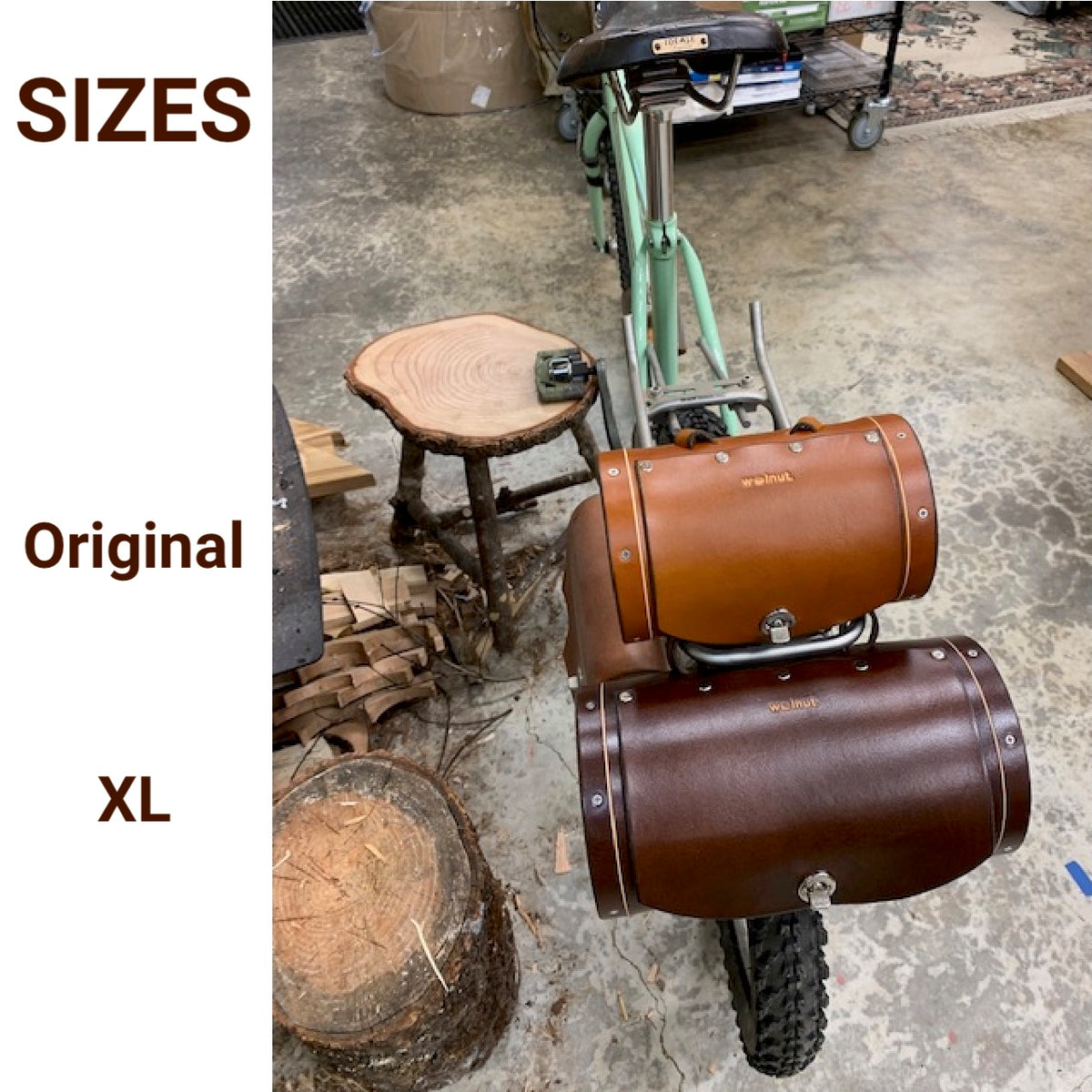 Bicycle with two brown leather barrel-shaped saddlebags next to each other, labeled 'Original' and 'XL' to show the two sizes right next to each other