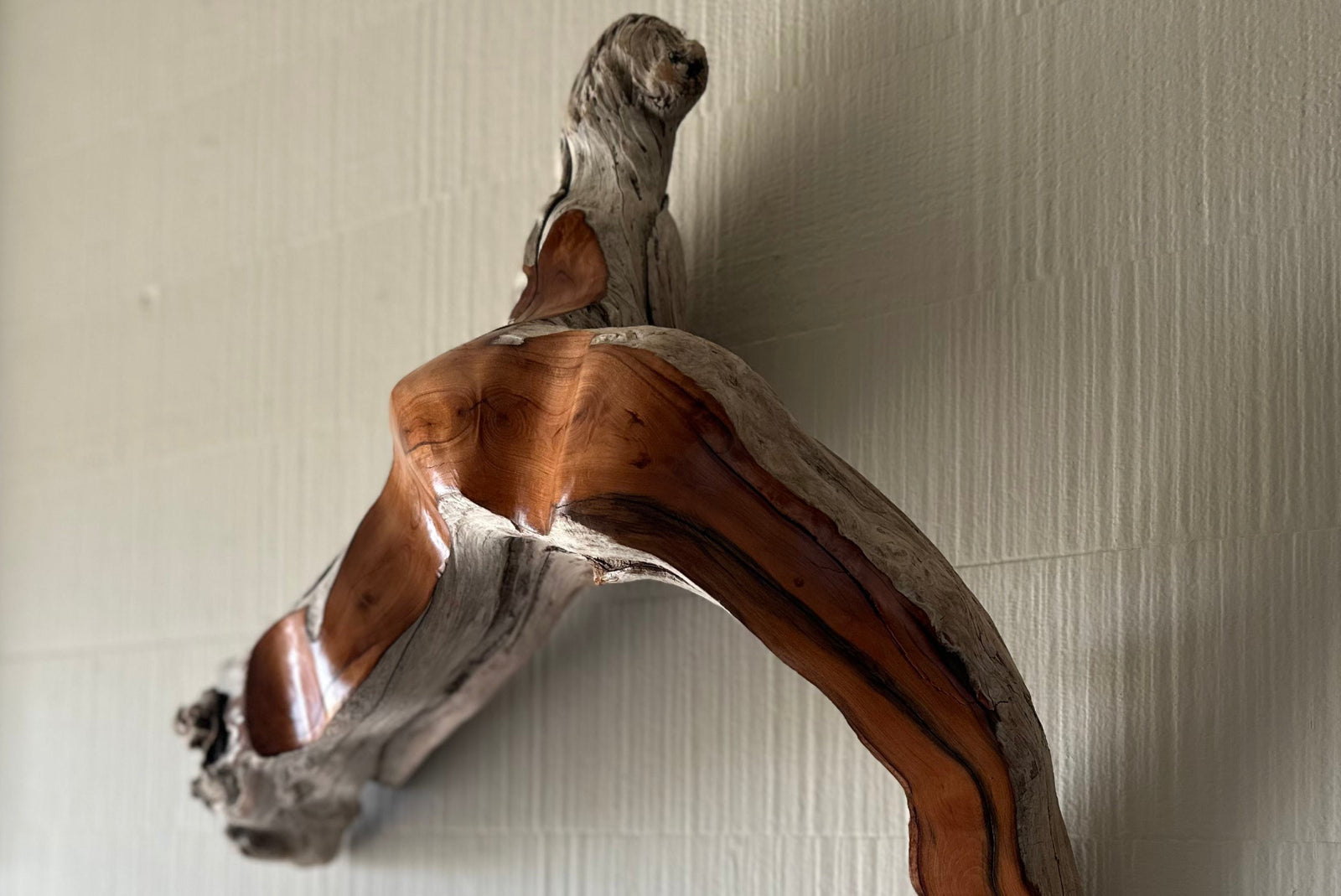 Wooden sculpture on a textured wall