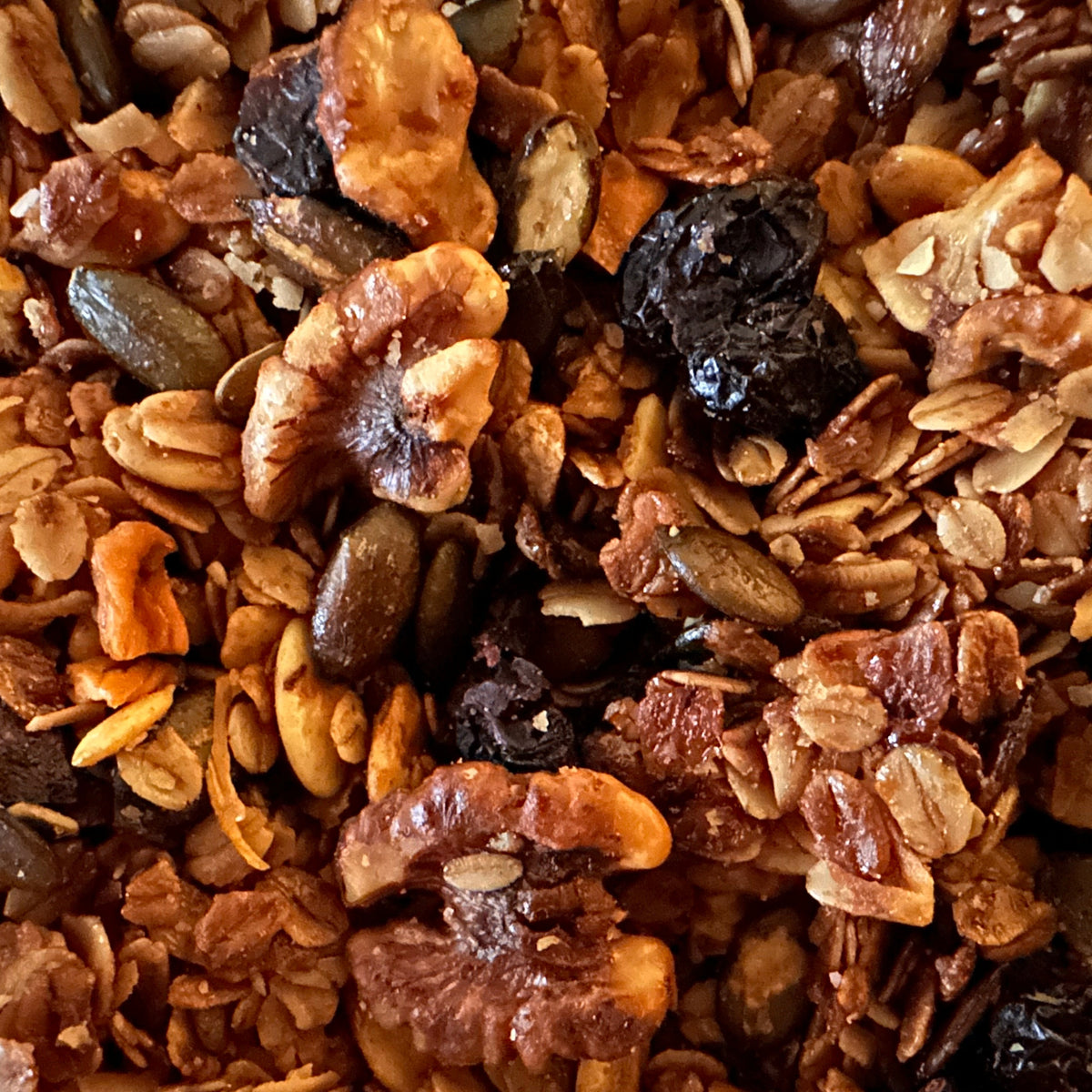 Close-up of a granola mixture with oats, nuts, and dried fruits.
