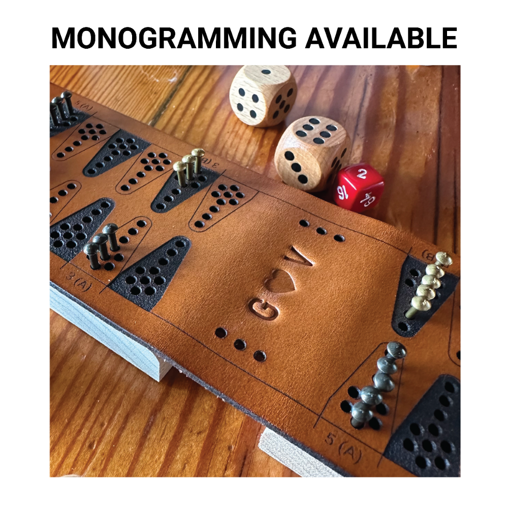 Close-up photo of the "spine" of a folding leather travel backgammon board that is monogrammed, G - heart symbol - V and written text above that says, Monogramming Available