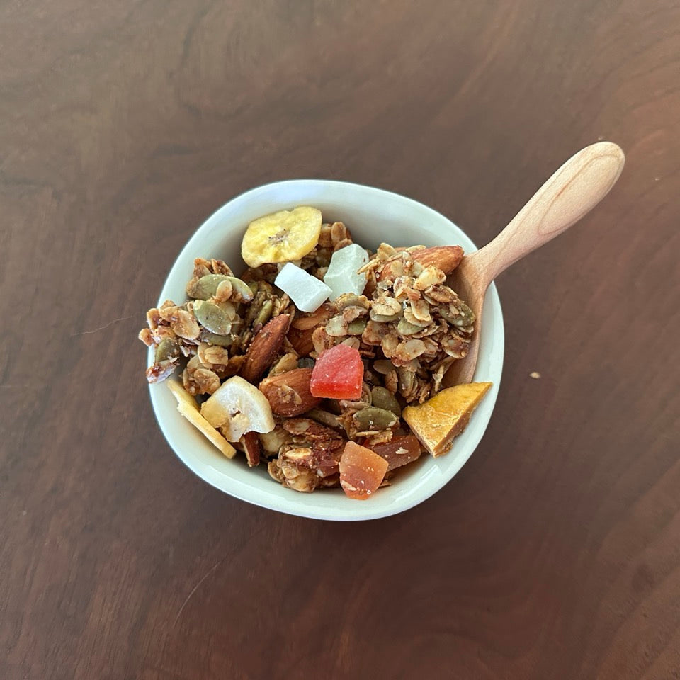Bowl of granola with dried fruits on a wooden table