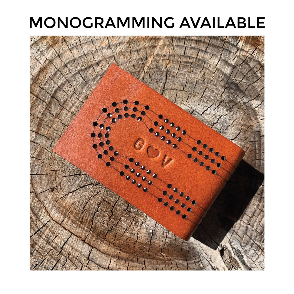 "monogramming available" meme shows the leather space inside the travel cribbage tracks with stamped initials and a heart. 